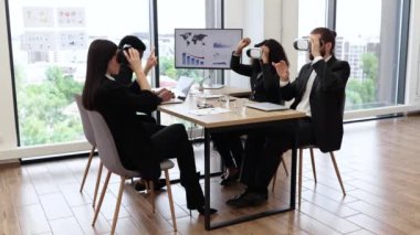 Modern ofis toplantısında sanal gerçeklik kulaklığı kullanan bir iş ekibi. Profesyoneller sunum için VR teknolojisine başvuruyorlar. Yenilik kavramı, dijital dönüşüm ve takım çalışması.