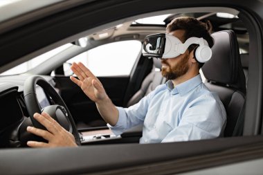 Sanal gerçeklik kulaklığı takan bir adam arabanın içinde oturuyor. Teknoloji, yenilik ve gelecekteki ulaşım kavramı. Sanal çevreyle etkileşim halinde olan işadamı VR teknolojisini tecrübe ediyor.