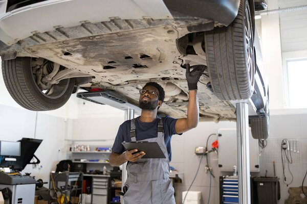 Professional Mechanic Carefully Inspecting Car Undercarriage Lift Modern Auto Repair Royalty Free Stock Images