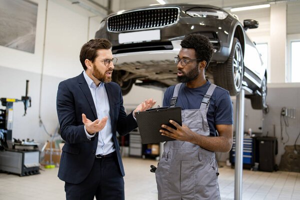 Mechanic Businessman Workshop Discussing Car Repair Details While Standing Next Royalty Free Stock Images