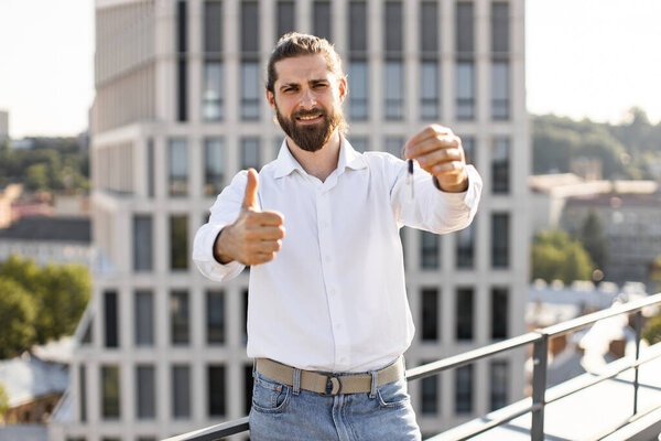 Bearded Man White Shirt Standing Rooftop Holding Key Showing Thumb Royalty Free Stock Images