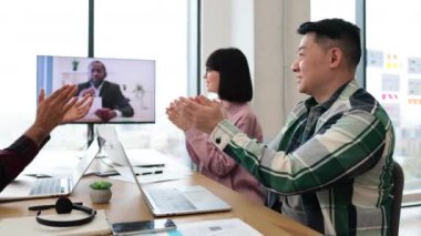 İş adamları iş arkadaşlarıyla konferans görüşmesi yapıyor, alkışlarla başarı ve takdirlerini ifade ediyorlar, laptoplar ve belgelerle toplantı masasında oturuyorlar, verimli bir çalışma seansı yapıyorlar..