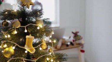 Noel 'de Noel ağacının süsleri ve ışıklarla süslendiği güzel bir sahne. Bulanık arkaplan, tatil dekorasyonlu yemek masasını gösteriyor.