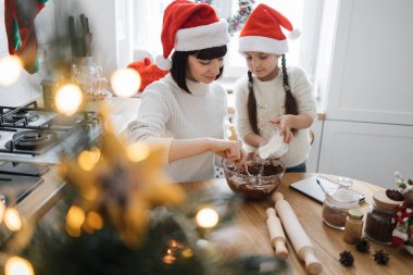 Kafkas anne ve kızı bayram pastasının tadını çıkarıyorlar. İkisi de Noel Baba şapkası takıyor. Mutfakta birlikte hamur yoğuruyorlar. Etrafı Noel süsleriyle çevrili..