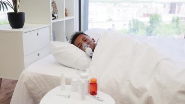 Grip olmuş Afrikalı çocuk evde nebulizatörle nefes alıp veriyor. Olay yeri bakımı, hastalık, iyileşme ve ev sağlığı hizmetlerini taşır.