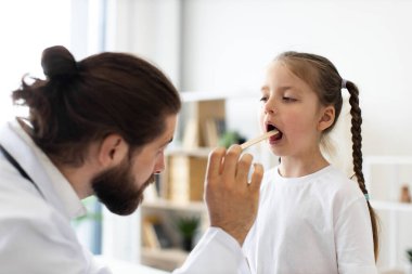 Kafkasyalı erkek doktor, kontrol sırasında boğaz depresifli genç bir kızı muayene ediyor. Kız sakince oturur sağlık uzmanı parlak sağlık bürosunda teftiş yapar..