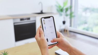 Beyaz bir kadın akıllı telefondan kozmetik ürünlerine göz atıyor. Resim dijital alışveriş deneyimini yakalar, evden güzellik ürünleri satın almanın kolaylığını vurgular.
