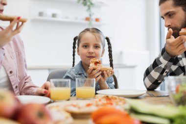 Kafkas ailesi kahvaltıdan zevk alıyor. Ailesi mutfak masasında pizza yiyen genç bir kız. Baba, anne ve çocukla sabah yemeğiniz kutlu olsun..