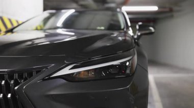 Park yeraltı otoparkındaki gösterişli modern arabanın ön farları yakın plan tasarım ve tarzını gösteriyor..