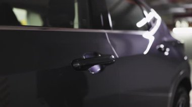 Beyaz kadın eli iş elbisesi içinde siyah araba kapısını açıyor, profesyonelliği ve seyahati simgeliyor..