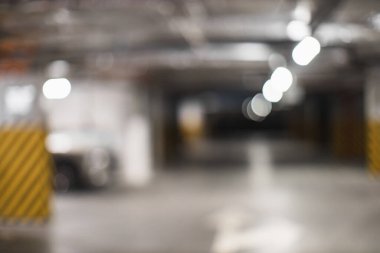 Bulanık yeraltı otoparkının parlak tepe lambalarıyla gösterilen soyut görüntü rüya gibi bir atmosfer yaratıyor. Kentsel yaşam, gizem veya modern çevre temaları için mükemmel.