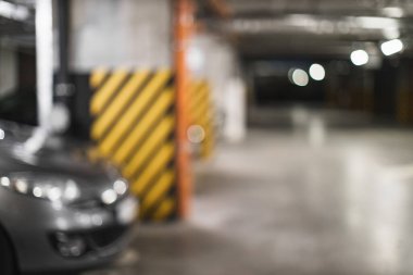 Bulanık bir yeraltı otoparkı görüntüsü, bulanık ışıklandırma ve belirsiz yapılar rüya gibi bir atmosfer yaratıyor..