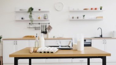 Modern beyaz mutfak ortamında pişirme hazırlıkları için gerekli malzemeler ve gereçler