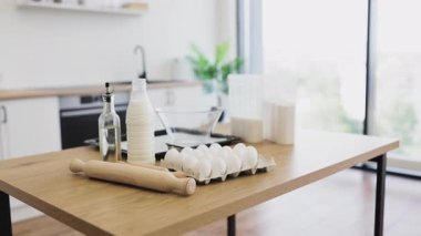 Malzemeler modern bir iç mekanda mutfak tezgahına düzgünce dizilmiş, pişirmeye hazır. Minimalist tasarım, yumuşak nötr tonlarla örgütlenmeyi ve işlevselliği teşvik eder.