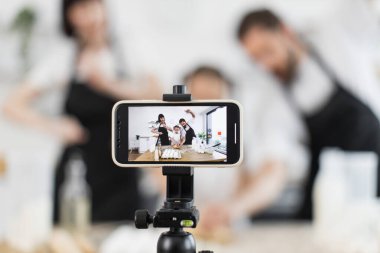 Farklı yaşlarda beyaz bir aile mutfakta hamur hazırlarken yaratıcılık, neşe ve mutfak eğlencesini ön plana çıkarıyor.