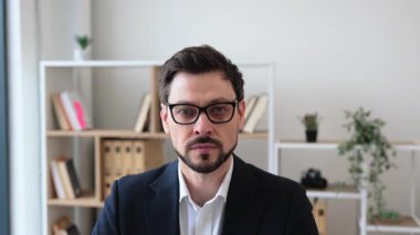 Masada dizüstü bilgisayarlı ve çeşitli malzemelerle çalışan kendine güvenen yetişkin bir erkek. Profesyonel ofis..