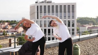 Kıdemli erkek ve kadın dışarıda beden eğitimi uyguluyor, esnekliği ve sağlığı geliştiriyor, güneşli bir gün..