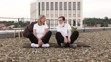 Üst düzey erkek ve kadın çatıda oturmuş dışarıda yoga egzersizleri yapıyorlardı. Meditasyon, sağlık, rahatlama ve kentsel refahı temsil eder. Mankenler gündelik giysiler içindeki yaşlı yetişkinlerdir.