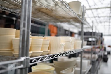 Çeşitli boyutlarda saksılar bir bahçe merkezindeki raflarda satışa sunuluyor..