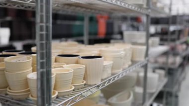 Çeşitli boyutlarda saksılar bir bahçe merkezindeki raflarda satışa sunuluyor..