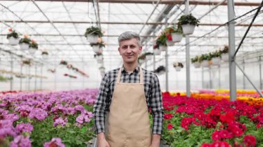 Serada dost canlısı bir adam her şeyin mükemmel olduğunu gösteren canlı çiçeklerle çevrili bir 