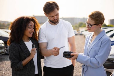 Çeşitli bir çift yeni bir araba satın alıyor, kredi kartıyla ödeme yapıyor ve bir galerideki arkadaş canlısı bir satıcıdan anahtarları alıyor..