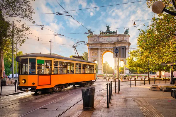 Old tram near the Arch of Peace in Milan at sunrise