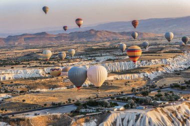 Türkiye 'de güneş doğarken Cappdocia vadilerinde sıcak hava balonları