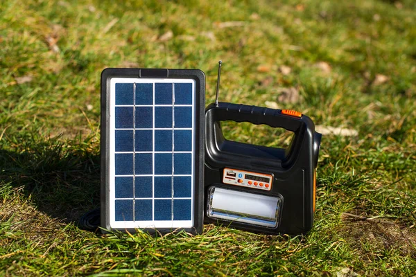 A large power bank for outdoor recreation, charged by a solar panel. Portable power station on ecological energy. Power plant for outdoor recreation