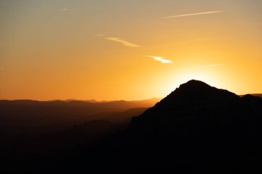 Sedona Arizona dağları üzerinde dramatik bir gün batımı. Uzaktaki dağ katmanlarıyla..