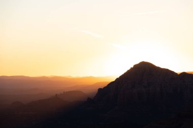 Sedona Arizona dağları üzerinde dramatik bir gün batımı. Uzaktaki dağ katmanlarıyla..