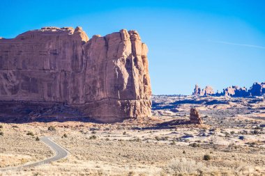 A road winding through the desert landscape of Arches National Park in Utah.