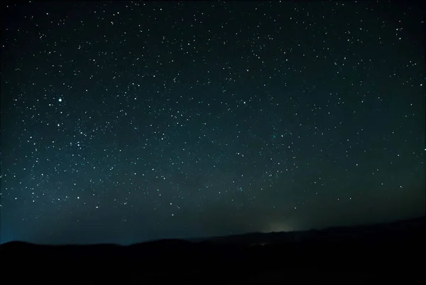 Звезды Ночного Неба Сияющие Сквозь Световое Загрязнение Далекого Города Горами — стоковое фото