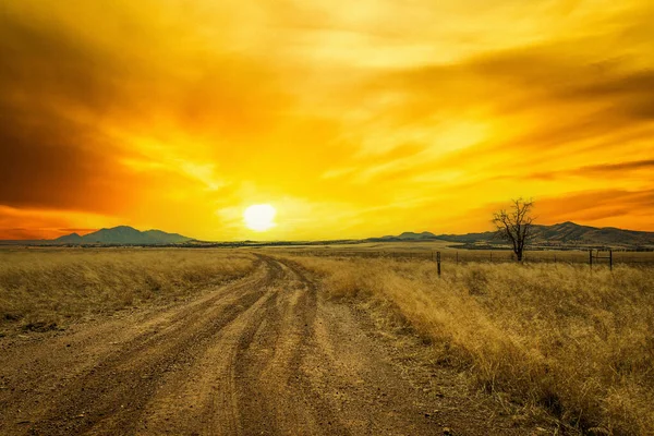 Eine Unbefestigte Straße Die Den Sonnenuntergang Mit Dramatisch Farbigem Himmel — Stockfoto