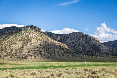 Arizona 'daki uzak dağlarla parçalı bulutlu gökyüzünün altında kurak bir manzara.