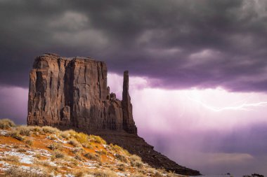 Arizona ve Utah 'taki Monument Valley' de fırtına bulutları ve şimşek güneşiyle klasik güneybatı çöl manzarası..