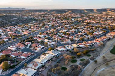 Tucson, Arizona yakınlarındaki dağ zemininde golf sahası olan bir banliyö yerleşim bölgesinin havadan görünüşü..
