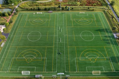 Aerial view of a multi-use playfield with soccer/lacrosse fields  and yellow and white lines in a suburban setting.