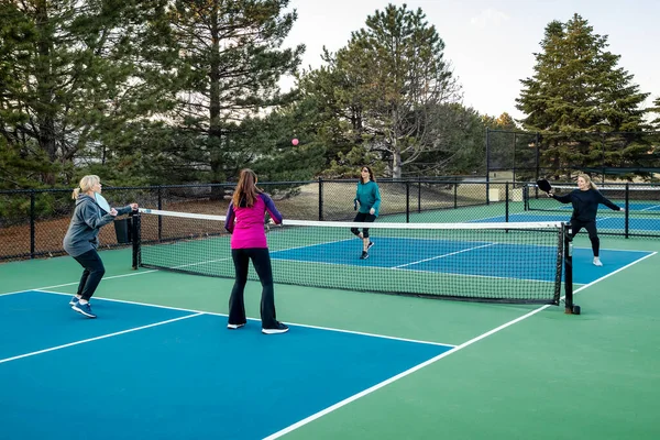 Four Women Pickleball Players Volley Pink Ball Net Blue Green — Stock Photo, Image