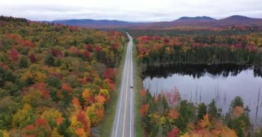 Eyalet otoyolu, New York 'un kuzeyindeki Adirondack Park' taki Panther Dağı Bataklığı yakınlarındaki Panter Gölü 'nü geçerek rengarenk sonbahar manzarasını ikiye böler..