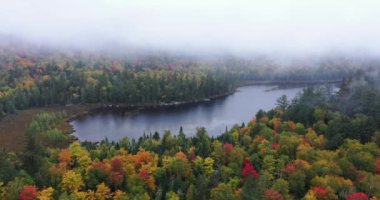 Connery Pond, New York, Adirondack Park 'taki Whiteface Dağı' nın yakınındaki sis ve bulutların arasından sonbaharda görülüyor..