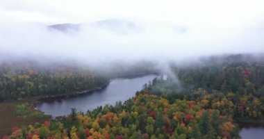 Connery Pond, New York, Adirondack Park 'taki Whiteface Dağı' nın yakınındaki sis ve bulutların arasından sonbaharda görülüyor..