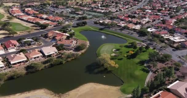 アリゾナ州ツーソン近くの背景にカタリナ山脈と砂漠の環境でゴルフコースとテニスコートと郊外の住宅コミュニティの空中ビュー — ストック動画