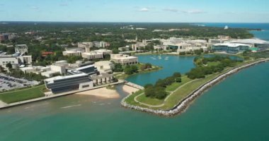 Michigan Gölü boyunca bir banliyö üniversitesinin ön plandaki plaj ve yürüyüş yolu manzarası..