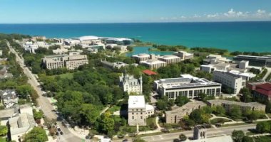 Michigan Gölü boyunca kampüs gölü ve çeşmeleri olan bir banliyö üniversitesinin havadan görünüşü.