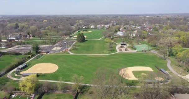 初春的郊区一个有棒球场 足球场 篮球场和游乐场的大公园的空中景观 — 图库视频影像
