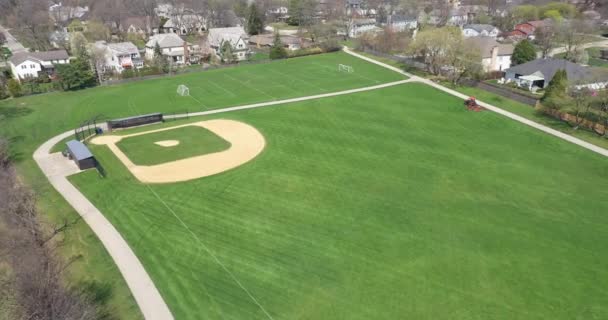 今年早春 在郊区的一个大公园里 空中看到了一个棒球场和足球场 那里有一台运动场割草机在修剪草坪 — 图库视频影像