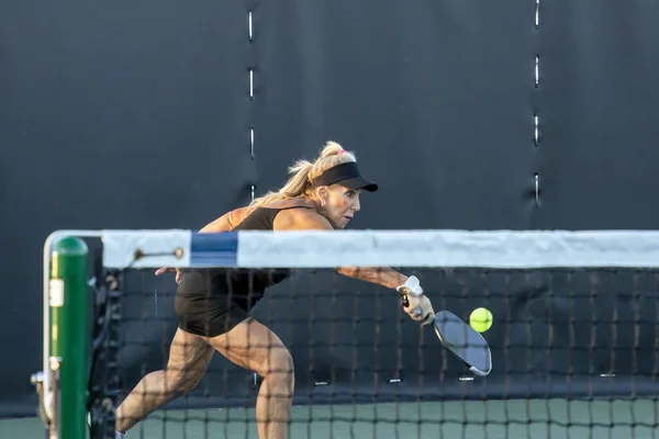 在一个专用的泡菜球场上 一名女泡菜手在网球场上回击 — 图库照片