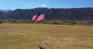 Ouray, Colorado yakınlarındaki San Juan Dağları 'nın olduğu bir vadide sonbaharda rüzgarda dalgalanan bir Amerikan Bayrağı görüntüsü