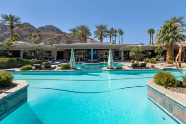 Güzel bir açık havuz, jakuzi ve dinlenme odası manzarası. Dağ zeni ve palmiye ağaçları. Indian Wells, California 'da büyük bir konut arazisinde..